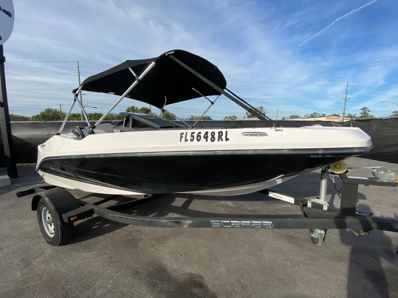 Slide: The Image of 2018 Scarab 165 G boat on trailer with canopy, parked outdoors. - 6
