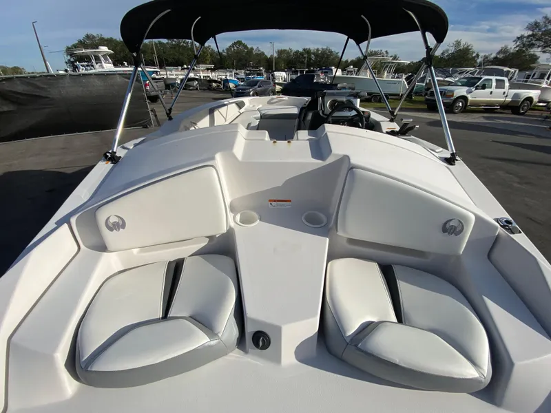 Slide: The Image of 2018 Scarab 165 G boat with seating and canopy in a marina setting. - 7