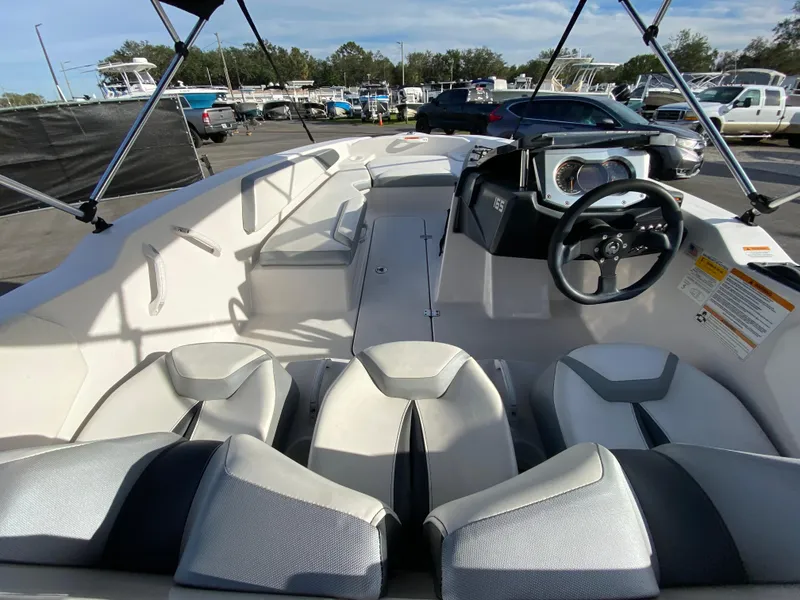 Slide: The Image of 2018 Scarab 165 G boat interior with seating and steering wheel, parked outdoors. - 9
