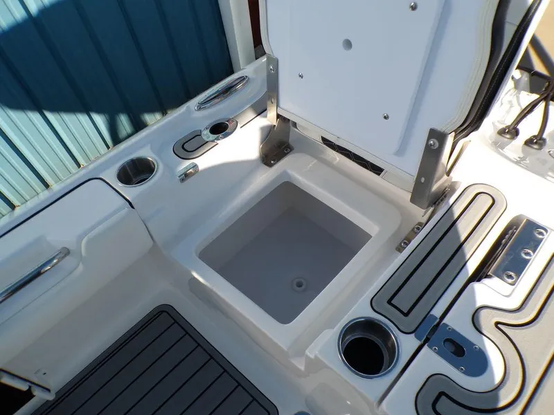 Slide: The Image of 2025 Tidewater 2700 CB boat interior with open storage compartment and cup holders. - 36