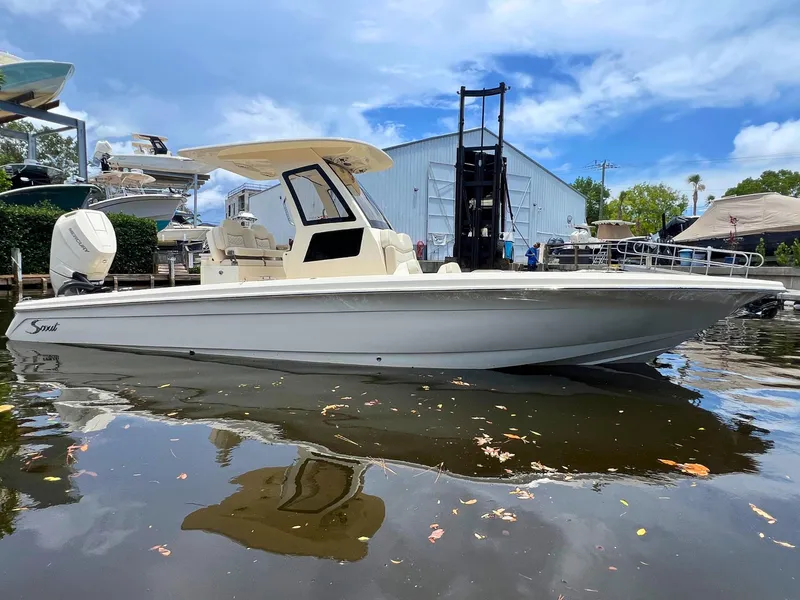 The Image of 2025 Scout 281 XSS boat docked on calm water, with clear blue sky background. - 0