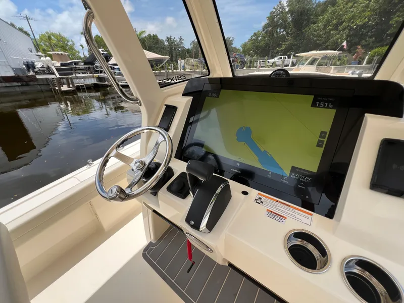 Slide: The Image of 2025 Scout 281 XSS boat dashboard with steering wheel and navigation display. - 12
