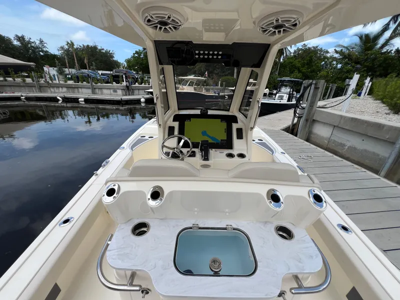 Slide: The Image of 2025 Scout 281 XSS boat interior with steering console and navigation screen at dock. - 14