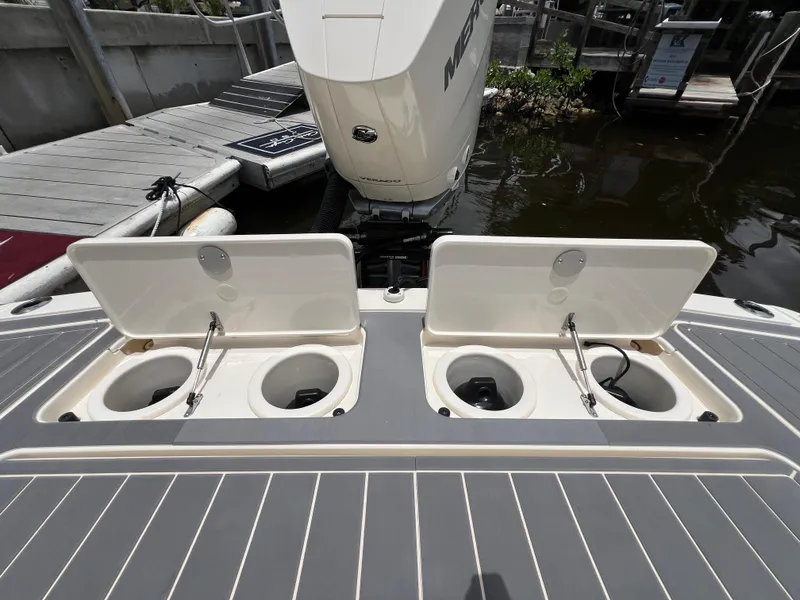 Slide: The Image of 2025 Scout 281 XSS boat with open storage compartments at the dock. - 19
