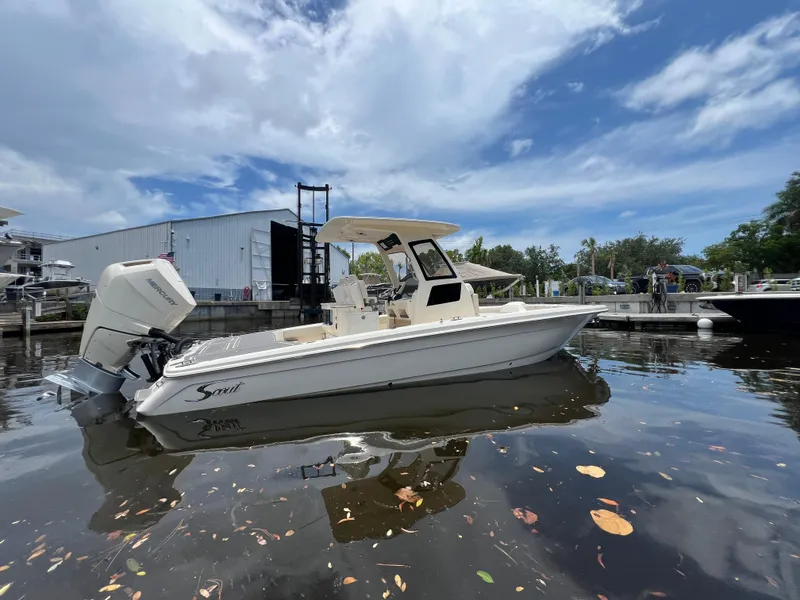 Slide: The Image of 2025 Scout 281 XSS boat docked on calm water under a partly cloudy sky. - 2