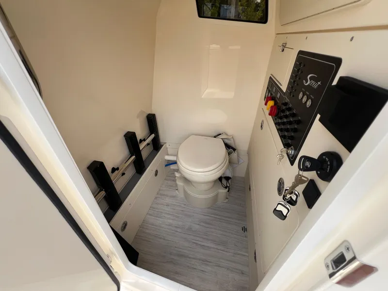 Slide: The Image of 2025 Scout 281 XSS boat interior with toilet and control panel. - 22