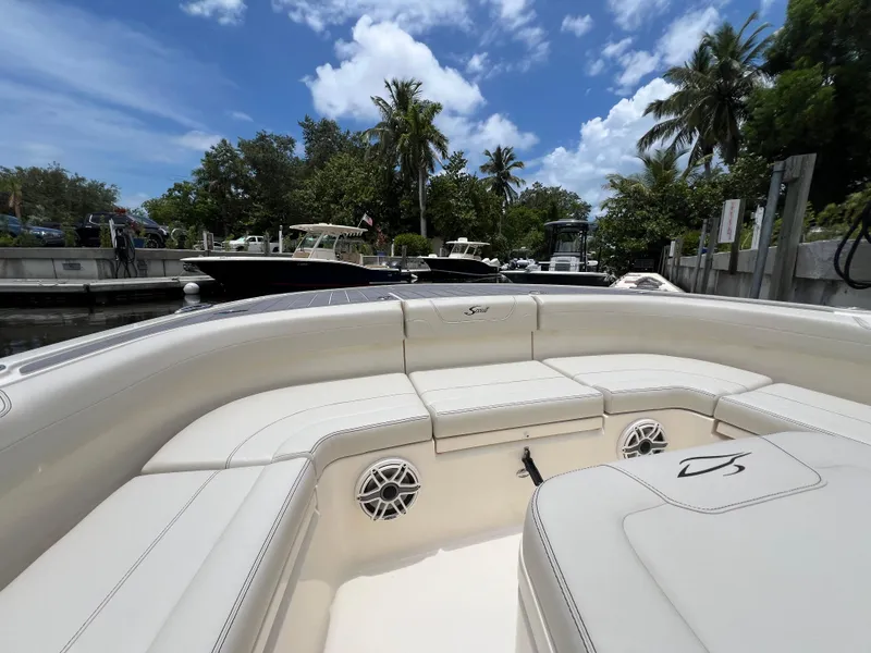 Slide: The Image of 2025 Scout 281 XSS boat interior with white seating, docked under a blue sky. - 5