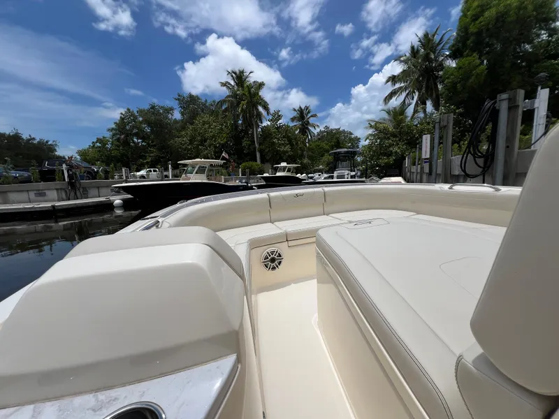 Slide: The Image of 2025 Scout 281 XSS boat docked, surrounded by lush greenery and clear blue sky. - 6