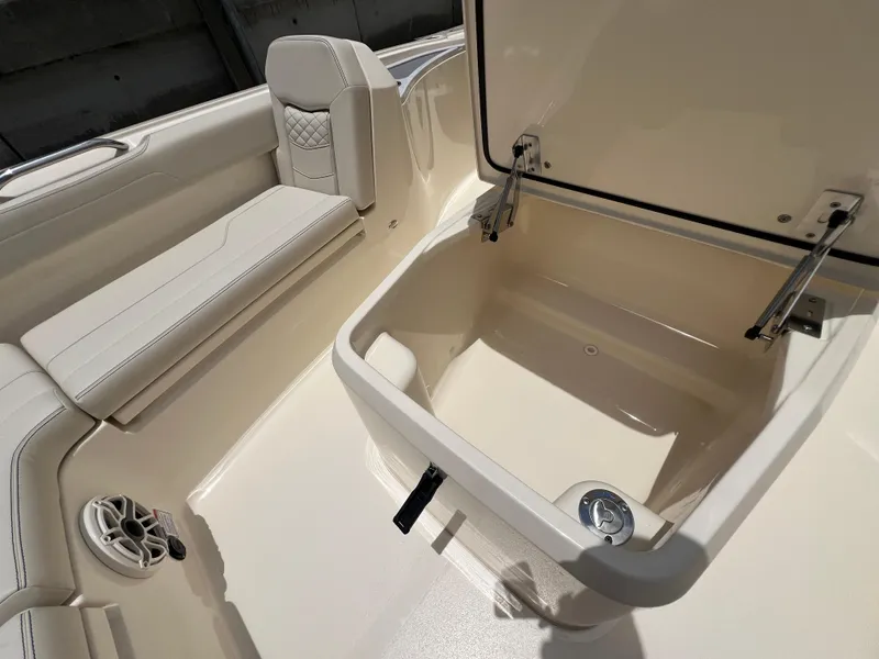 Slide: The Image of 2025 Scout 281 XSS boat interior with open storage compartment and cushioned seating. - 9
