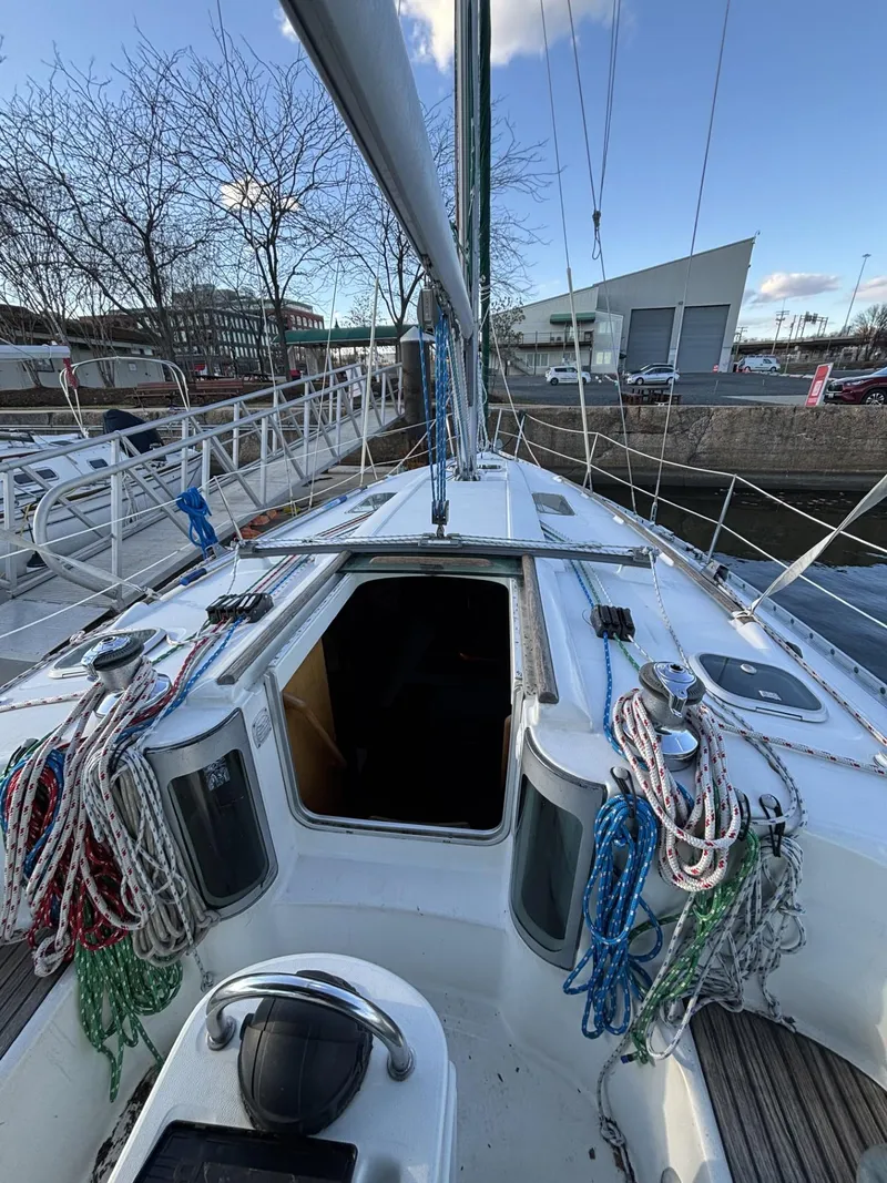 Slide: The Image of 1997 Beneteau Oceanis 351 sailboat deck with ropes and open cabin hatch. - 10