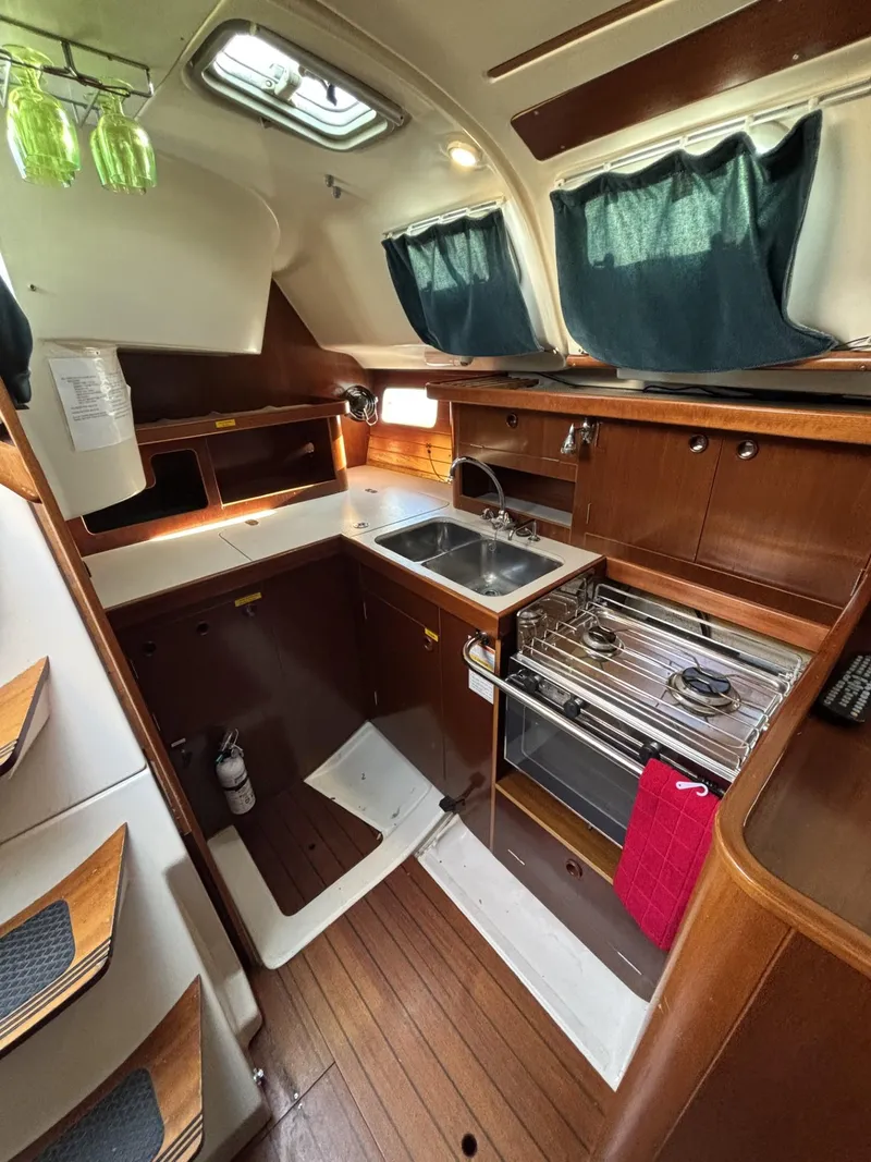 Slide: The Image of 1997 Beneteau Oceanis 351 yacht kitchen with wood cabinetry and modern appliances. - 11