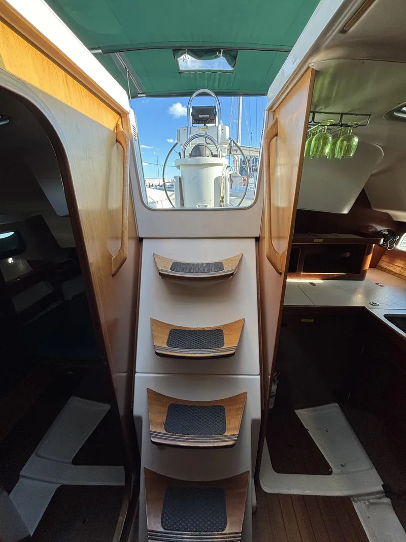 Slide: The Image of Interior view of 1997 Beneteau Oceanis 351 sailboat with wooden steps and cabin layout. - 12