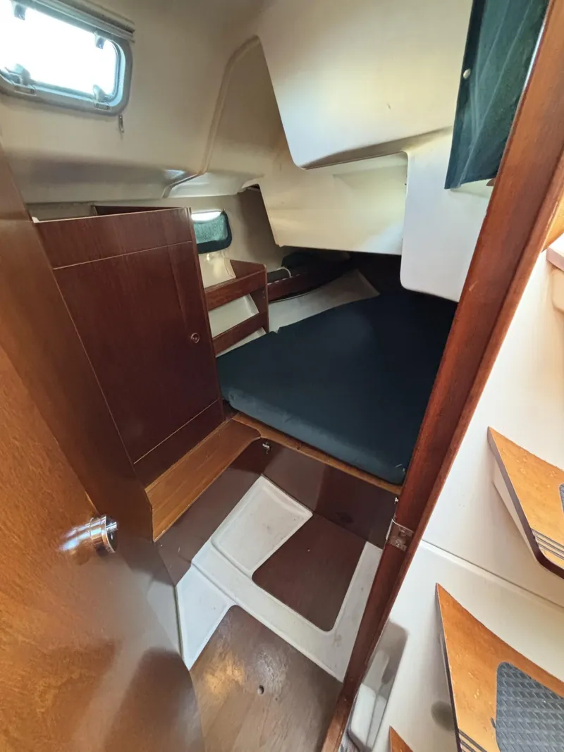 Slide: The Image of Interior cabin of 1997 Beneteau Oceanis 351 sailboat with wooden finishes and cozy sleeping area. - 13