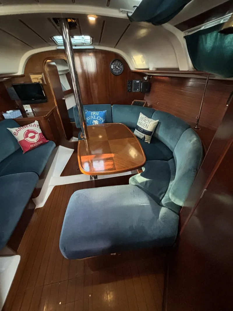 Slide: The Image of Interior of 1997 Beneteau Oceanis 351 sailboat with cozy seating and wooden table. - 17