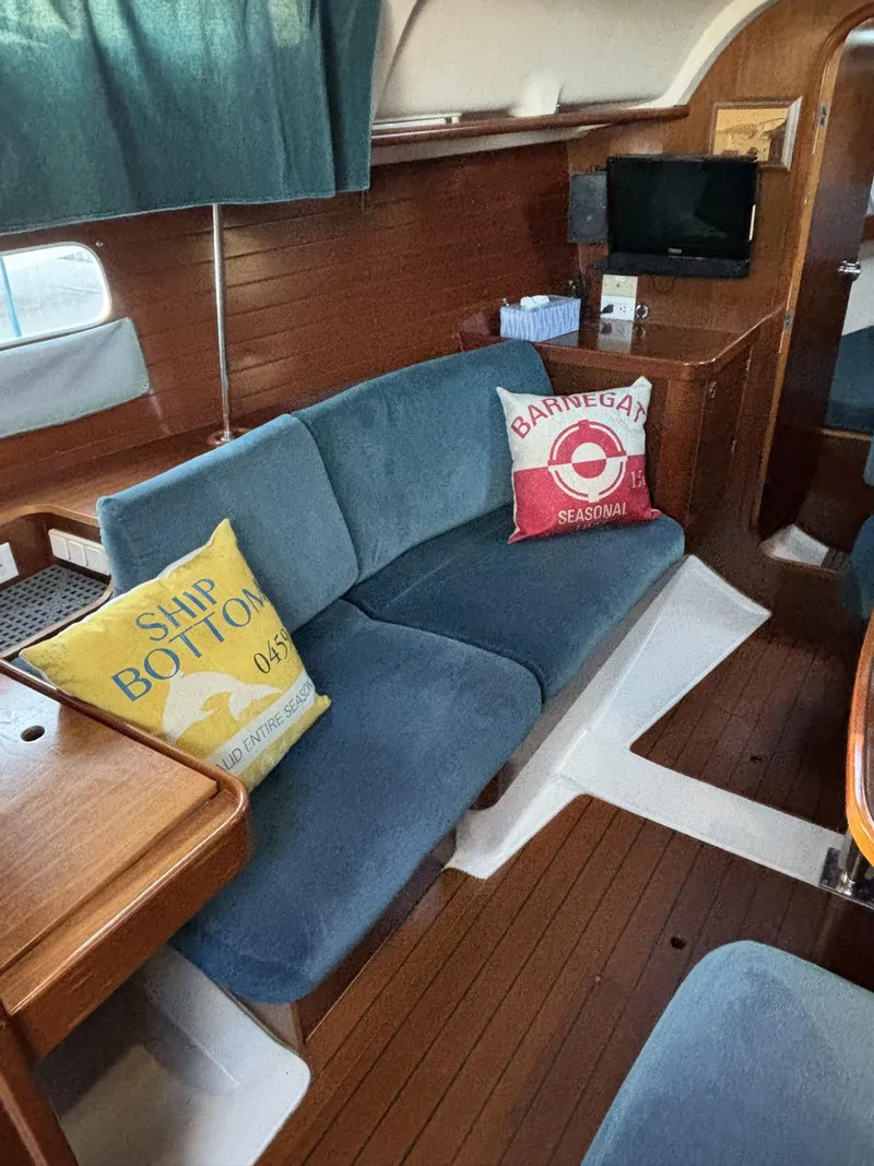 Slide: The Image of Interior of 1997 Beneteau Oceanis 351 sailboat with blue seating and decorative pillows. - 18