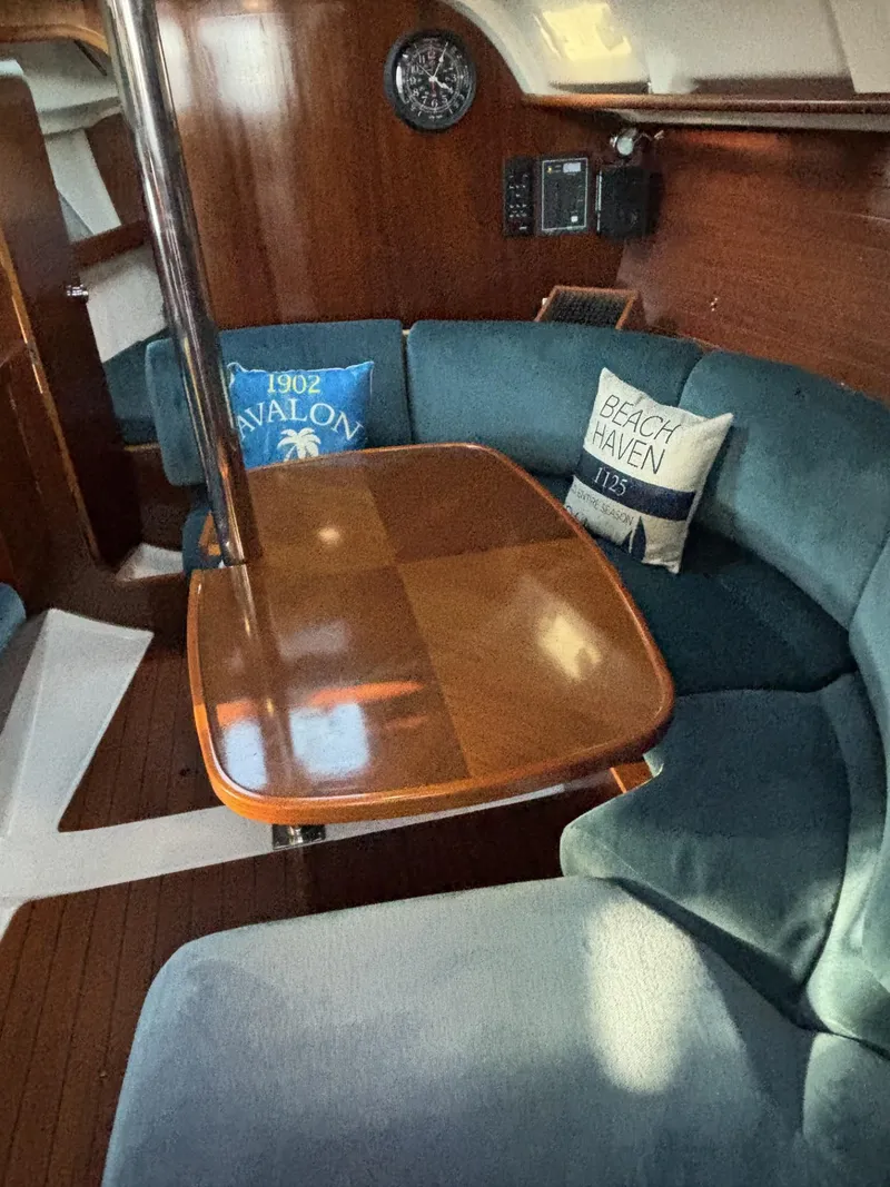 Slide: The Image of Cozy interior of 1997 Beneteau Oceanis 351 sailboat with wooden table and blue seating. - 19