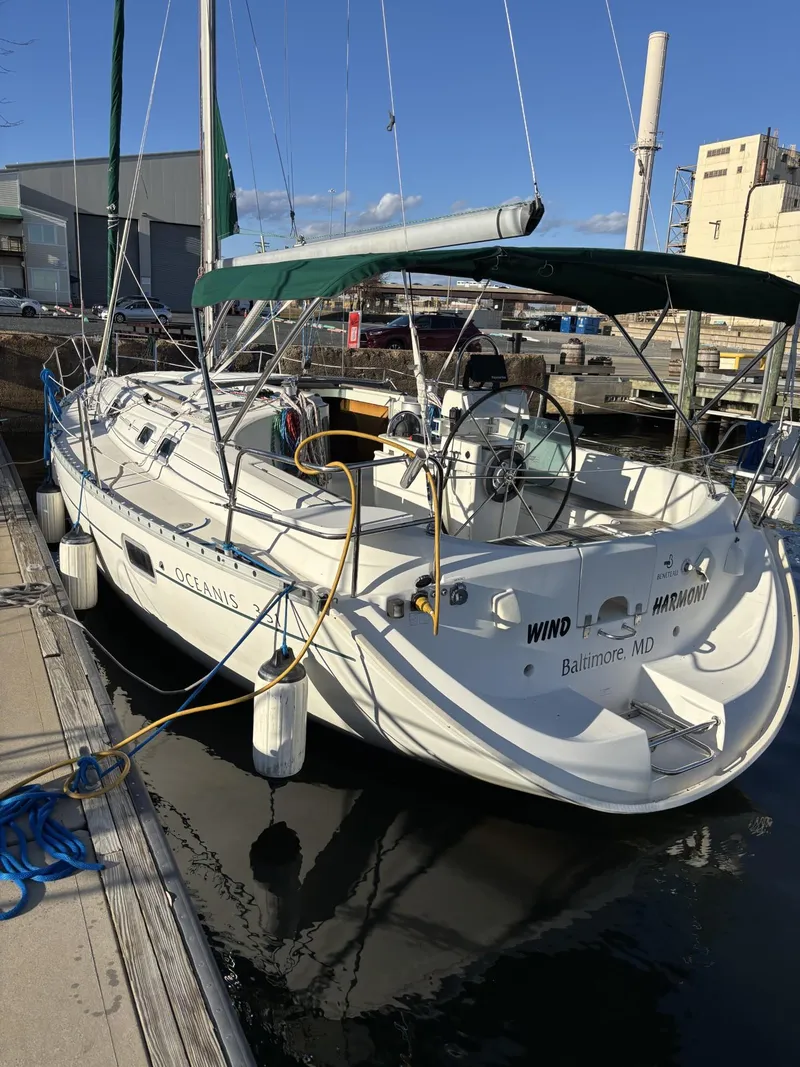 Slide: The Image of 1997 Beneteau Oceanis 351 sailboat docked at a marina, featuring a green canopy. - 2