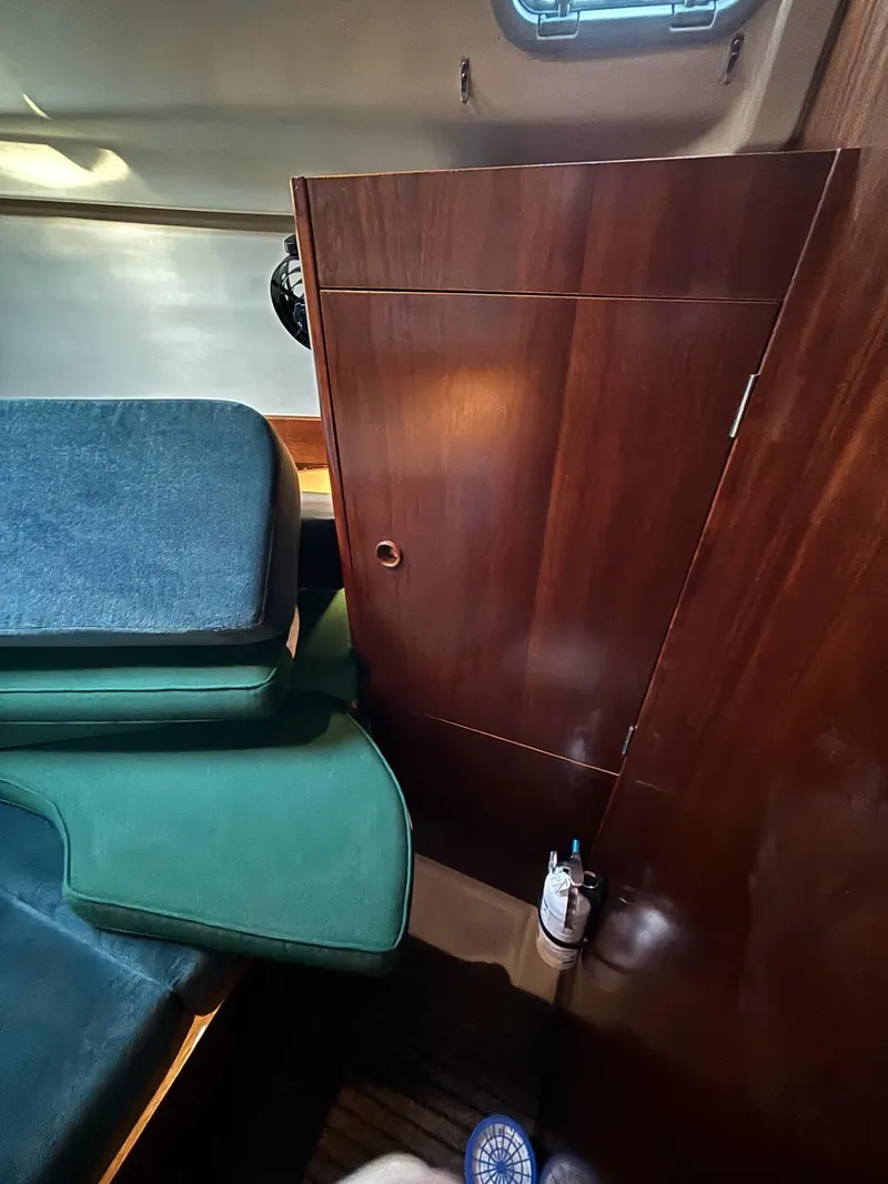 Slide: The Image of Interior of 1997 Beneteau Oceanis 351 sailboat with wooden cabinetry and green cushions. - 21