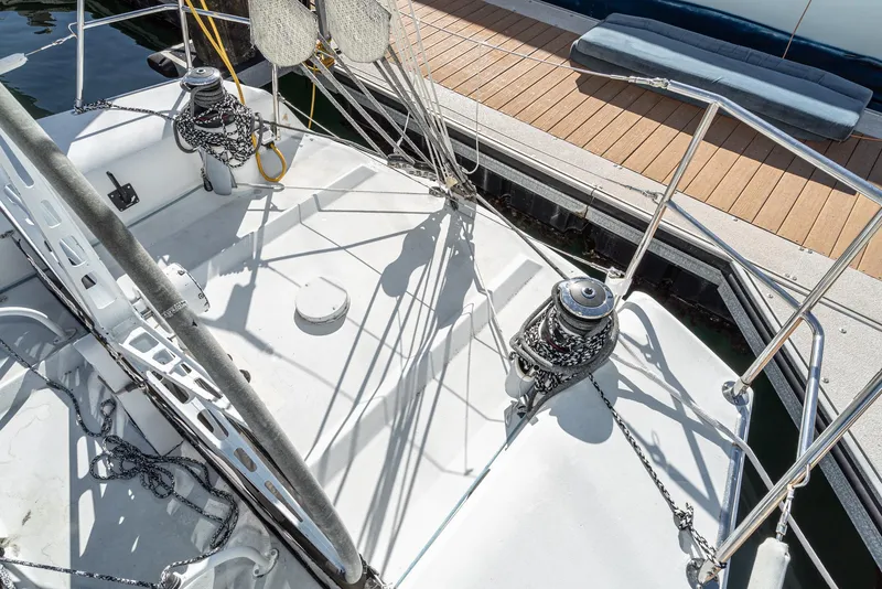 Slide: The Image of Sailboat deck of 1992 Tripp 47, featuring winches and rigging near a dock. - 10