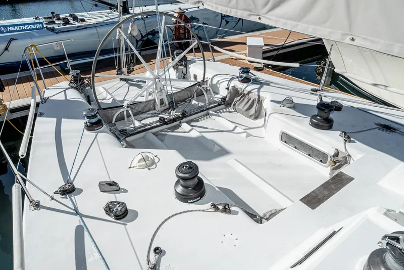 Slide: The Image of Sailboat deck of 1992 Tripp 47, featuring winches and steering wheel at marina. - 19