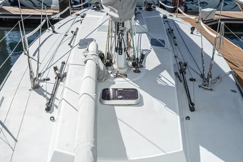 Slide: The Image of Deck view of a 1992 Tripp 47 sailboat, featuring rigging and a covered mast. - 27