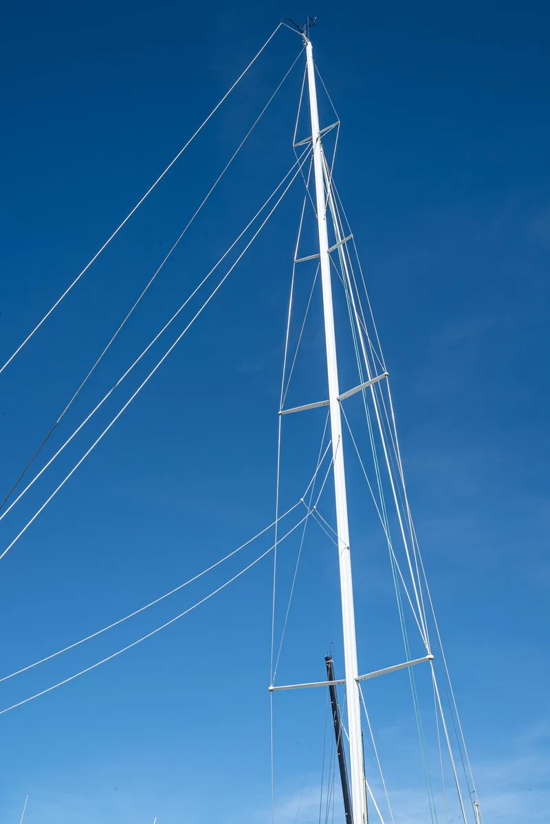 Slide: The Image of Tall sailboat mast against clear blue sky, Tripp 47, 1992 model. - 31