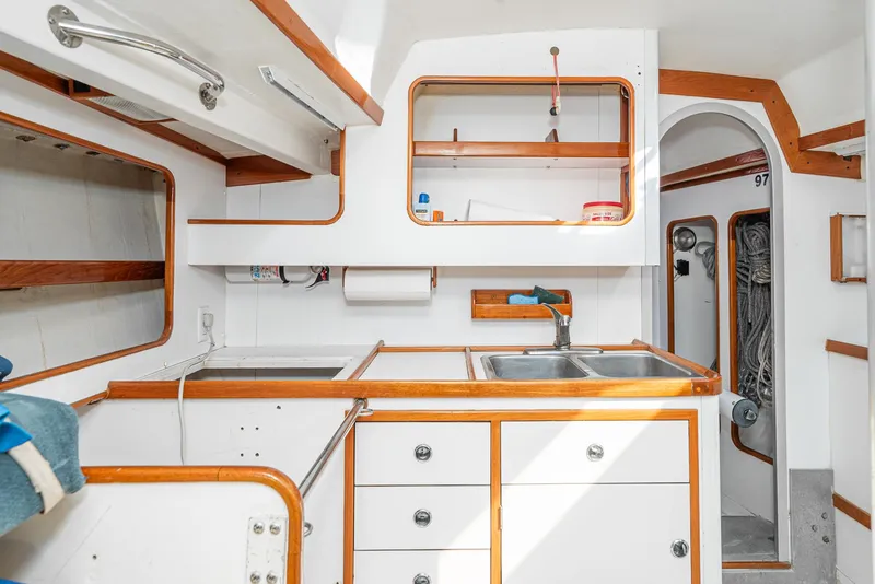 Slide: The Image of Interior of 1992 Tripp 47 sailboat kitchen with wooden accents and stainless steel sink. - 42