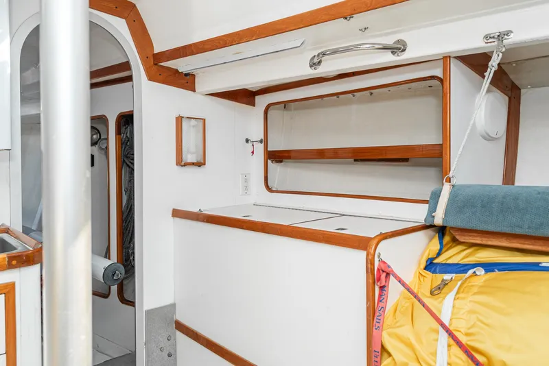 Slide: The Image of Interior of a 1992 Tripp 47 sailboat with wooden trim and storage compartments. - 43