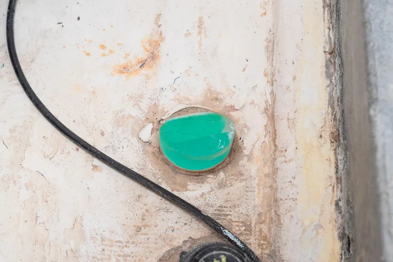 Slide: The Image of Green circular object on weathered surface, near black cable, Tripp 47, 1992. - 45