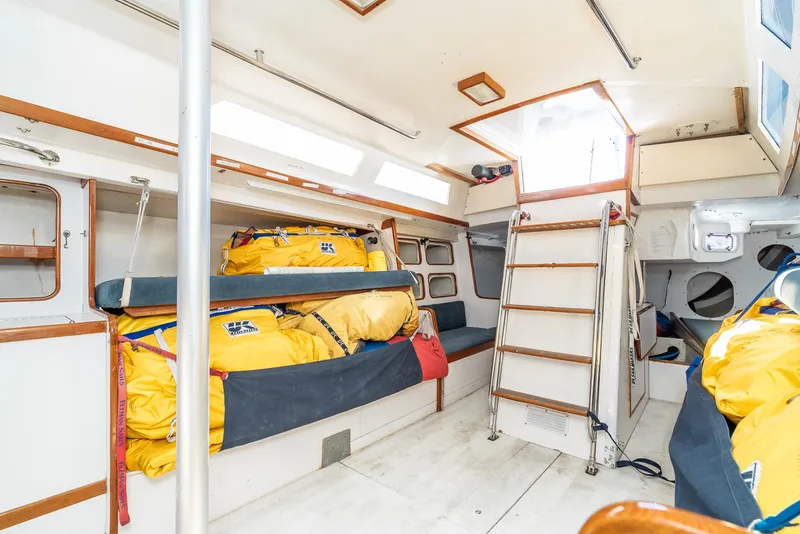 Slide: The Image of Interior of 1992 Tripp 47 sailboat with yellow life vests and wooden accents. - 48