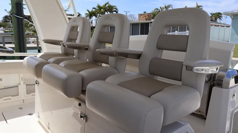 Slide: The Image of 2018 Boston Whaler 420 Outrage boat seats, featuring luxurious gray upholstery and armrests. - 29