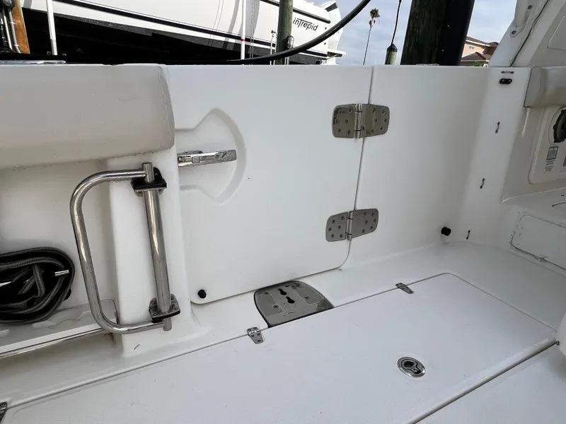 Slide: The Image of 2018 Boston Whaler 420 Outrage boat interior, featuring white deck and stainless steel fixtures. - 55