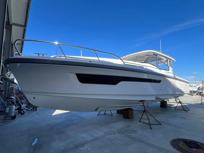 Slide: The Image of Nimbus W11 #46 2025 model boat on dry dock under clear blue sky. - 14