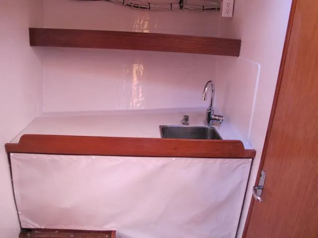 Slide: The Image of 1985 Santa Cruz 70 yacht interior with sink and wooden shelves. - 21