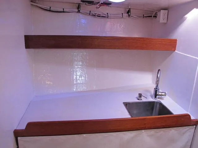 Slide: The Image of Compact kitchen sink area in a 1985 Santa Cruz 70 boat, featuring wooden accents. - 22