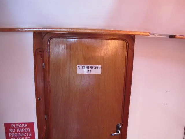 Slide: The Image of Wooden door with "Authorized Personnel Only" sign on a 1985 Santa Cruz 70 boat. - 25