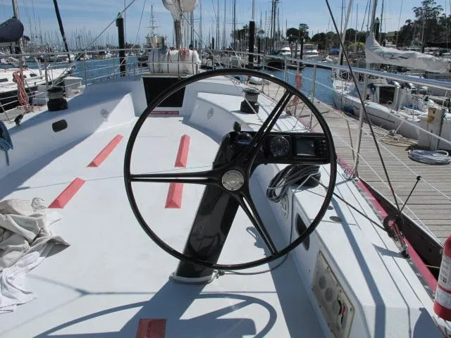 Slide: The Image of 1985 Santa Cruz 70 sailboat cockpit with steering wheel, docked at marina. - 34