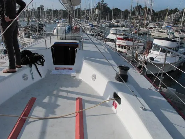 Slide: The Image of 1985 Santa Cruz 70 sailboat deck in marina, surrounded by other boats. - 35