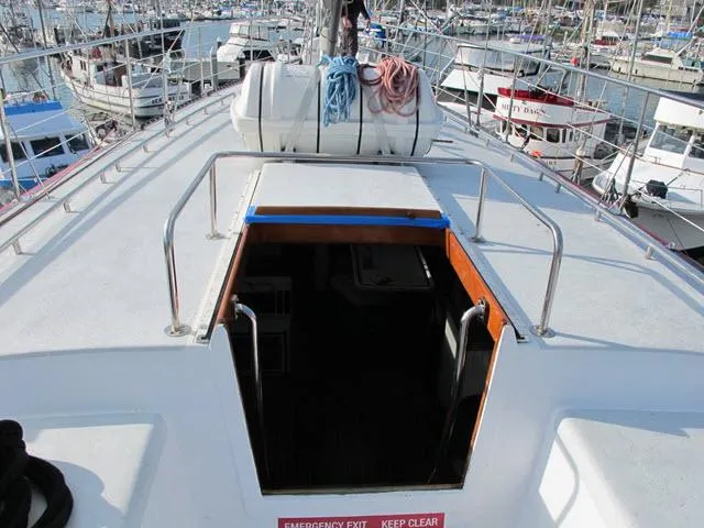 Slide: The Image of 1985 Santa Cruz 70 sailboat deck with open hatch in marina. - 38