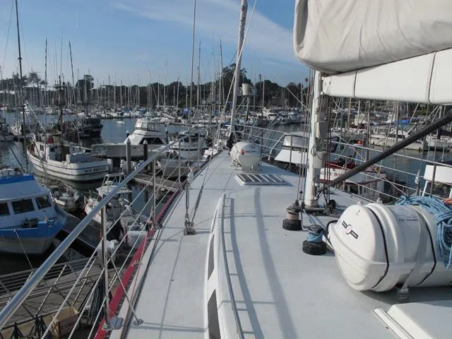Slide: The Image of 1985 Santa Cruz 70 sailboat docked in a busy marina. - 40