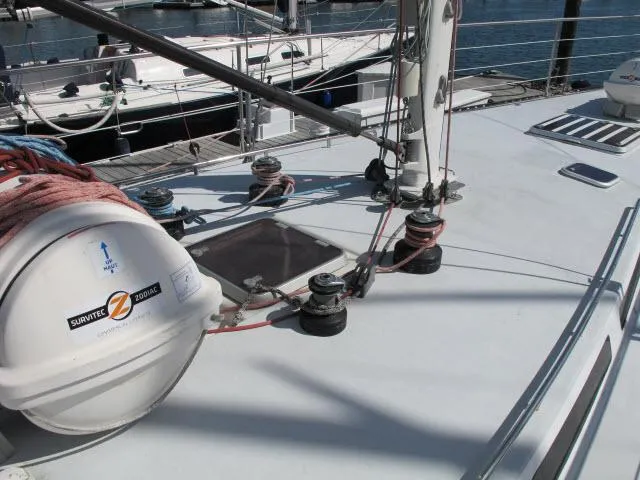Slide: The Image of 1985 Santa Cruz 70 sailboat deck with winches and liferaft at marina. - 43