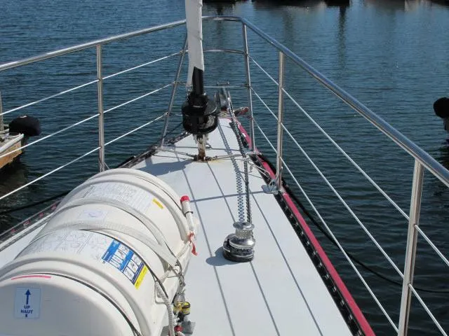 Slide: The Image of Santa Cruz 70 sailboat deck, 1985 model, with safety equipment and railing on calm water. - 44