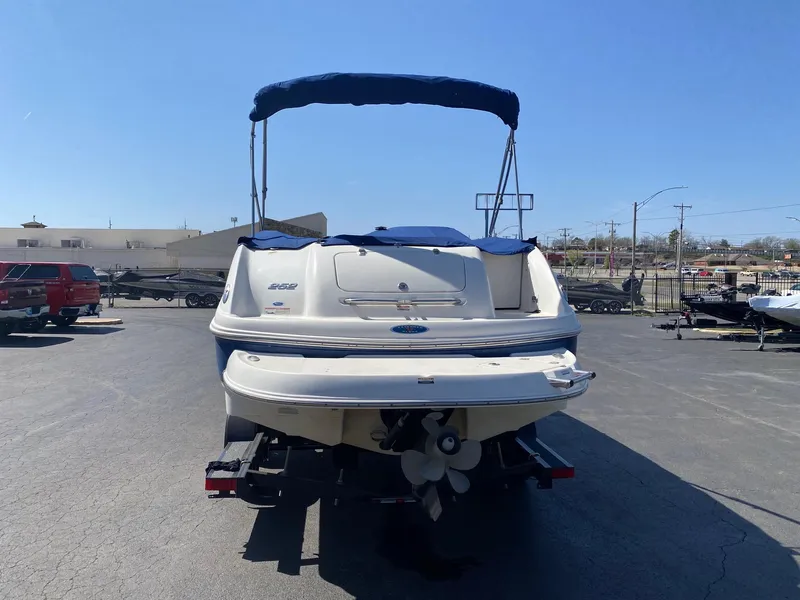 Slide: The Image of 2007 Chaparral Sunesta 252 boat with blue canopy, parked on a trailer in a lot. - 11