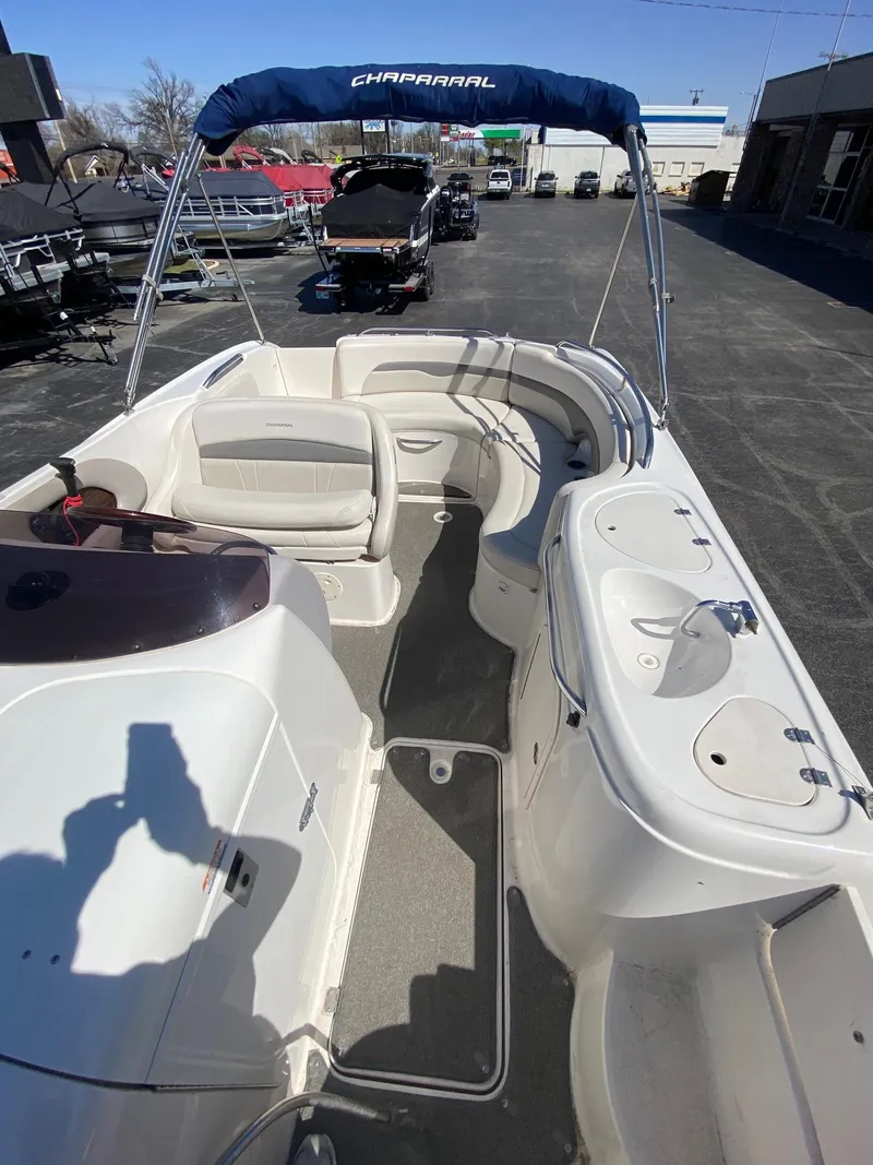 Slide: The Image of 2007 Chaparral Sunesta 252 boat interior with seating and canopy, parked outdoors. - 6