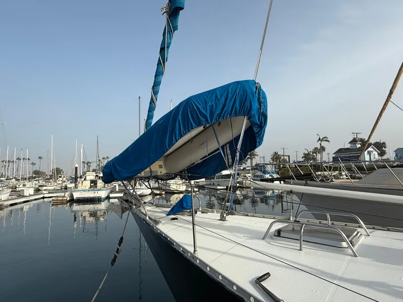 Slide: The Image of 1986 Beneteau Idylle 15.50 sailboat docked in marina, blue sail cover visible. - 11