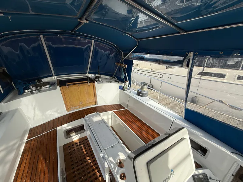 Slide: The Image of 1986 Beneteau Idylle 15.50 yacht cockpit with wooden flooring and blue canopy. - 19