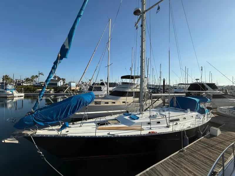 Slide: The Image of 1986 Beneteau Idylle 15.50 sailboat docked in a marina under clear skies. - 2