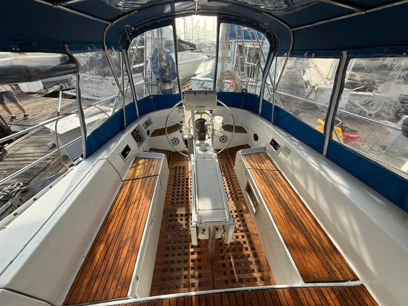 Slide: The Image of Cockpit of 1986 Beneteau Idylle 15.50 sailboat with wooden seating and steering wheel. - 22