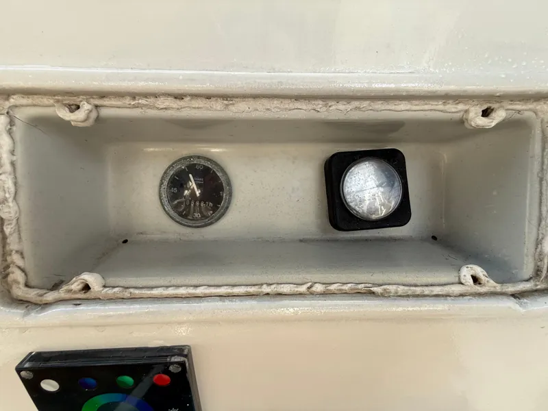 Slide: The Image of Control panel of a 1986 Beneteau Idylle 15.50 sailboat, featuring a gauge and button. - 27