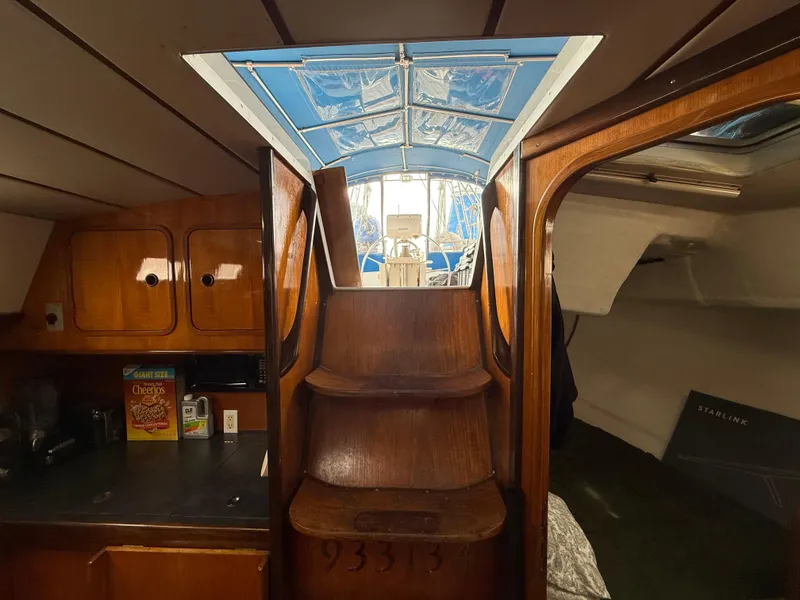 Slide: The Image of Interior view of 1986 Beneteau Idylle 15.50 sailboat, featuring wooden stairs and cabinetry. - 29